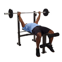 Person performing strength conditioning workout on a bench press with a barbell on a weight bench.