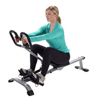 Woman working out on rowing exercise equipment against a white background
