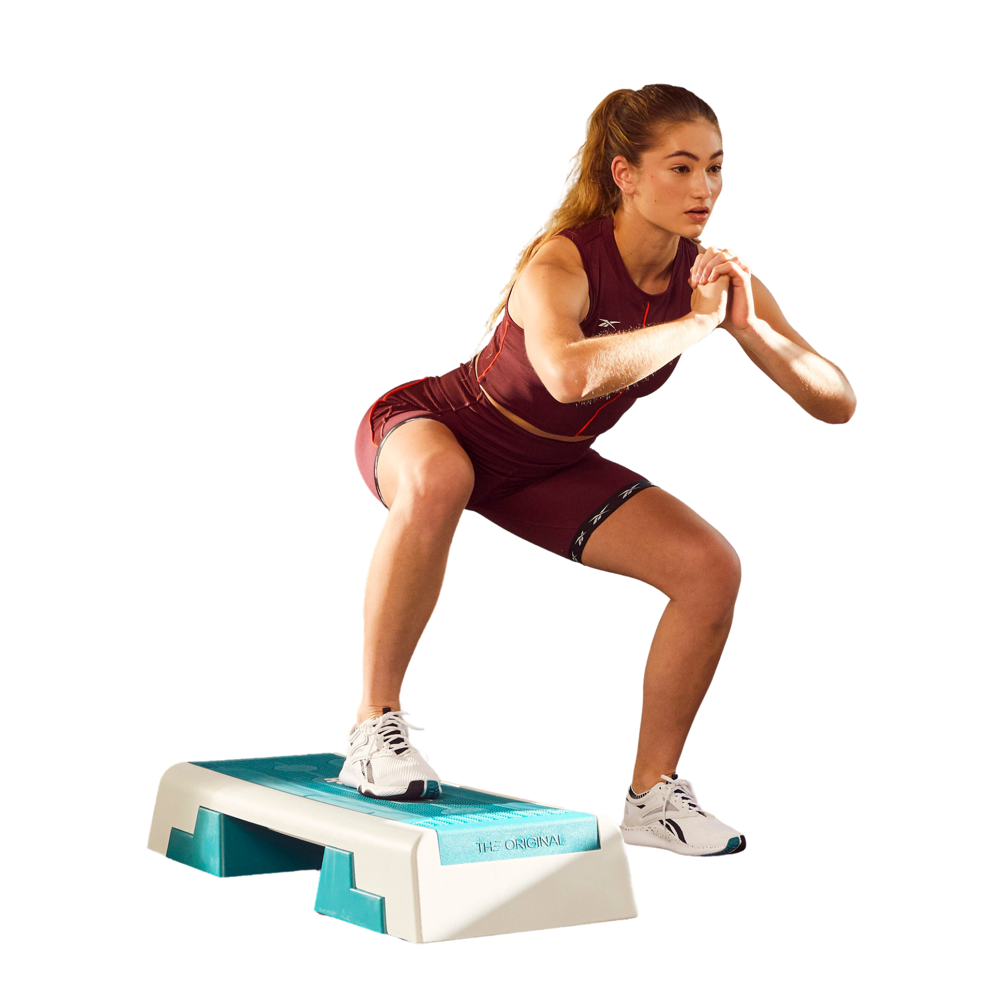 Woman exercising on a step platform against a white background