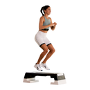 Woman exercising on a step platform against a white background