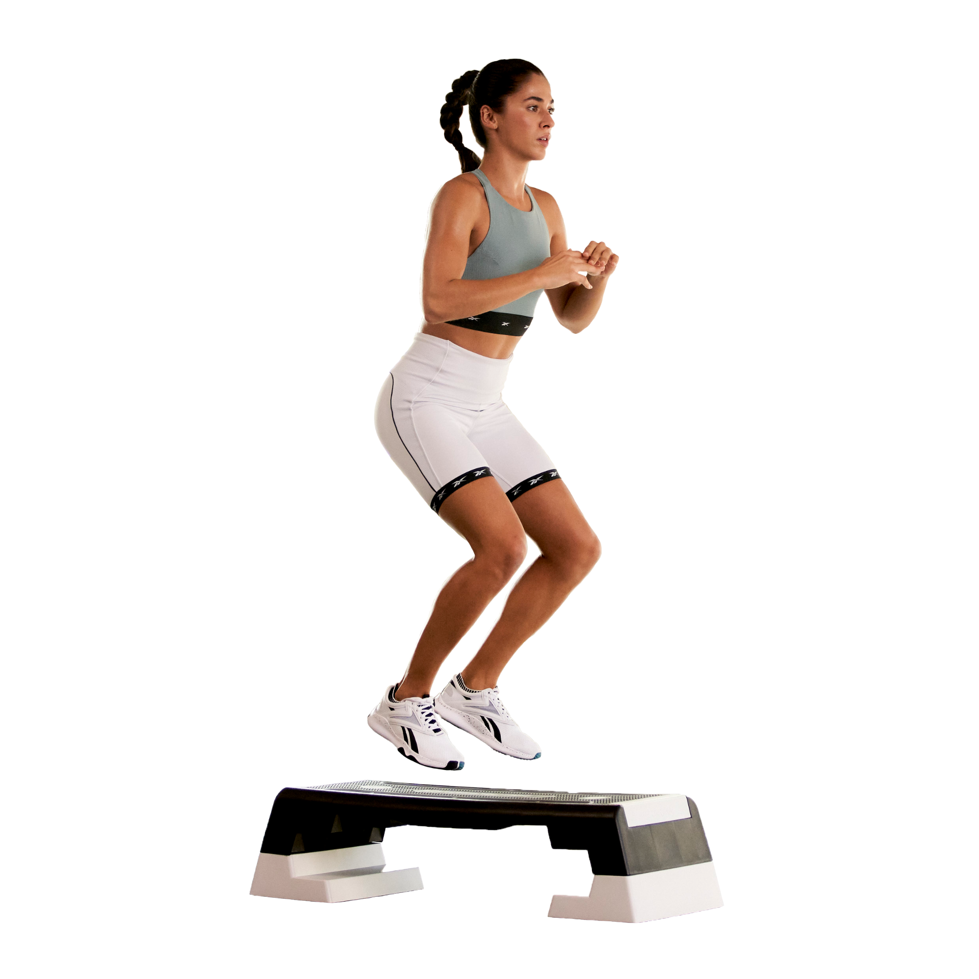 Woman exercising on a step platform against a white background