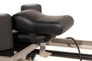 Close-up of a black exercise machine seat on a white background
