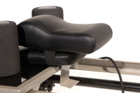 Close-up of a black exercise machine seat on a white background