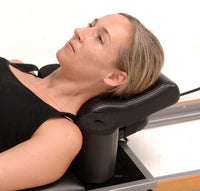 Woman using a neck and shoulder massager on a white background