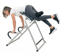 Woman using an inversion table on a white background