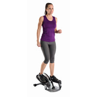 Woman using a mini stepper on a white background