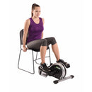 Woman using a mini exercise bike attached to a chair on a white background