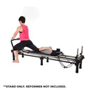 Woman using a Pilates exercise equipment part on a white background