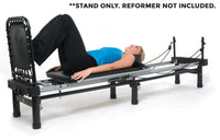 Woman lying on a reformer machine with text indicating reformer not included.