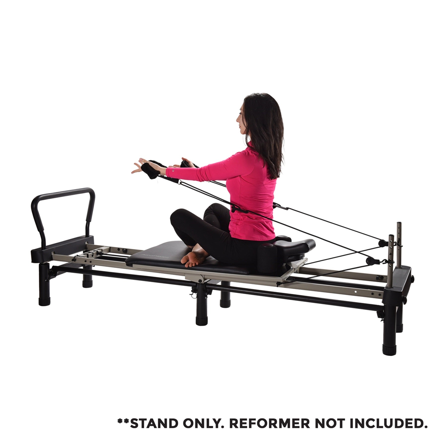 Woman using a Pilates reformer machine on a white background