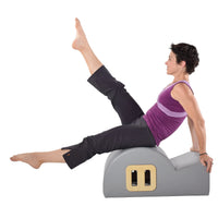 Woman using a Pilates back stretching equipment on a white background