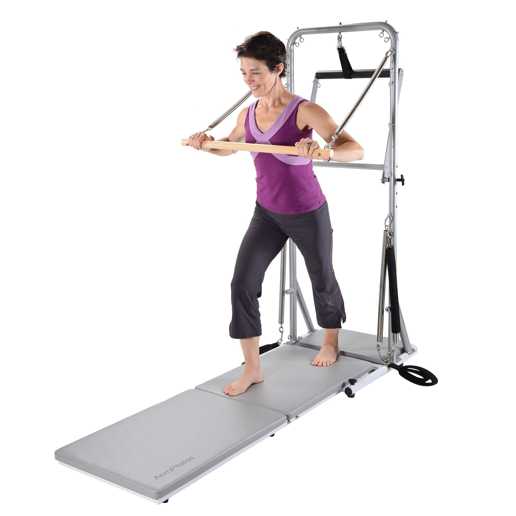 Woman using a Pilates reformer machine on a white background