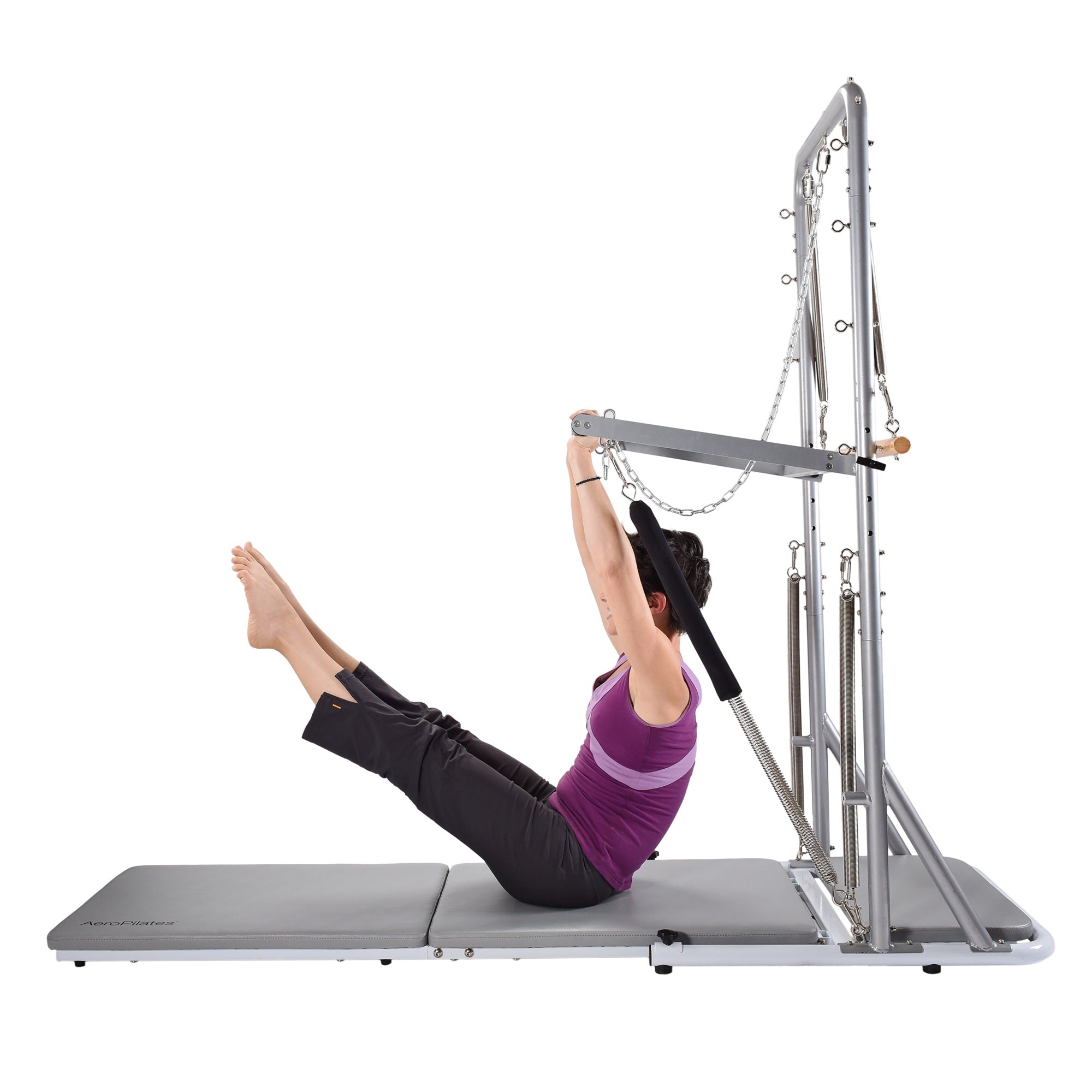 Person using a Pilates reformer machine on a white background