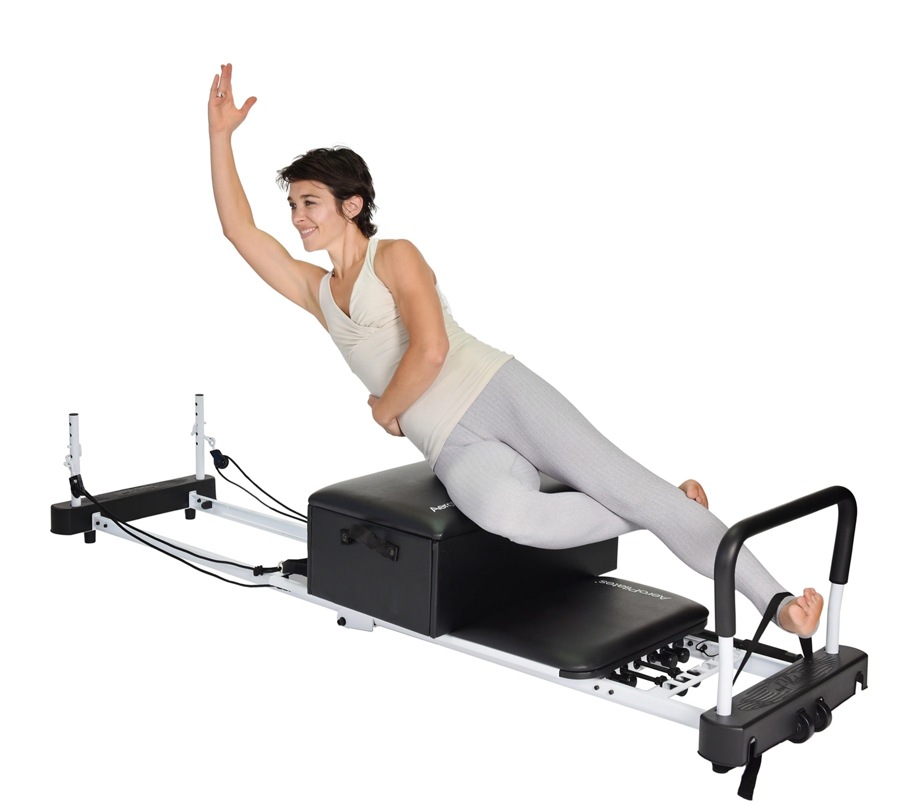 Woman using a Pilates reformer machine on a white background