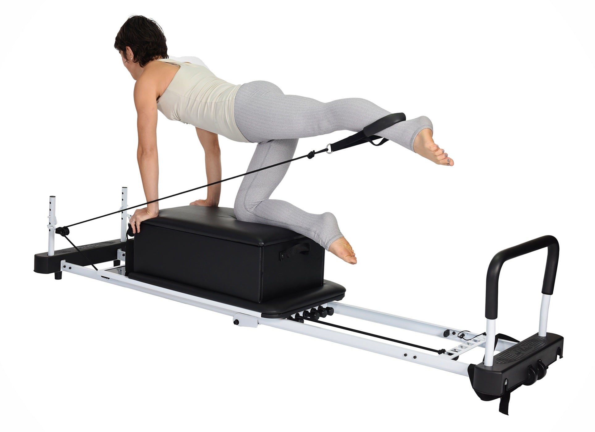 Person using a Pilates reformer machine on a white background