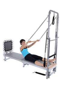 Person using a Pilates reformer machine on a white background