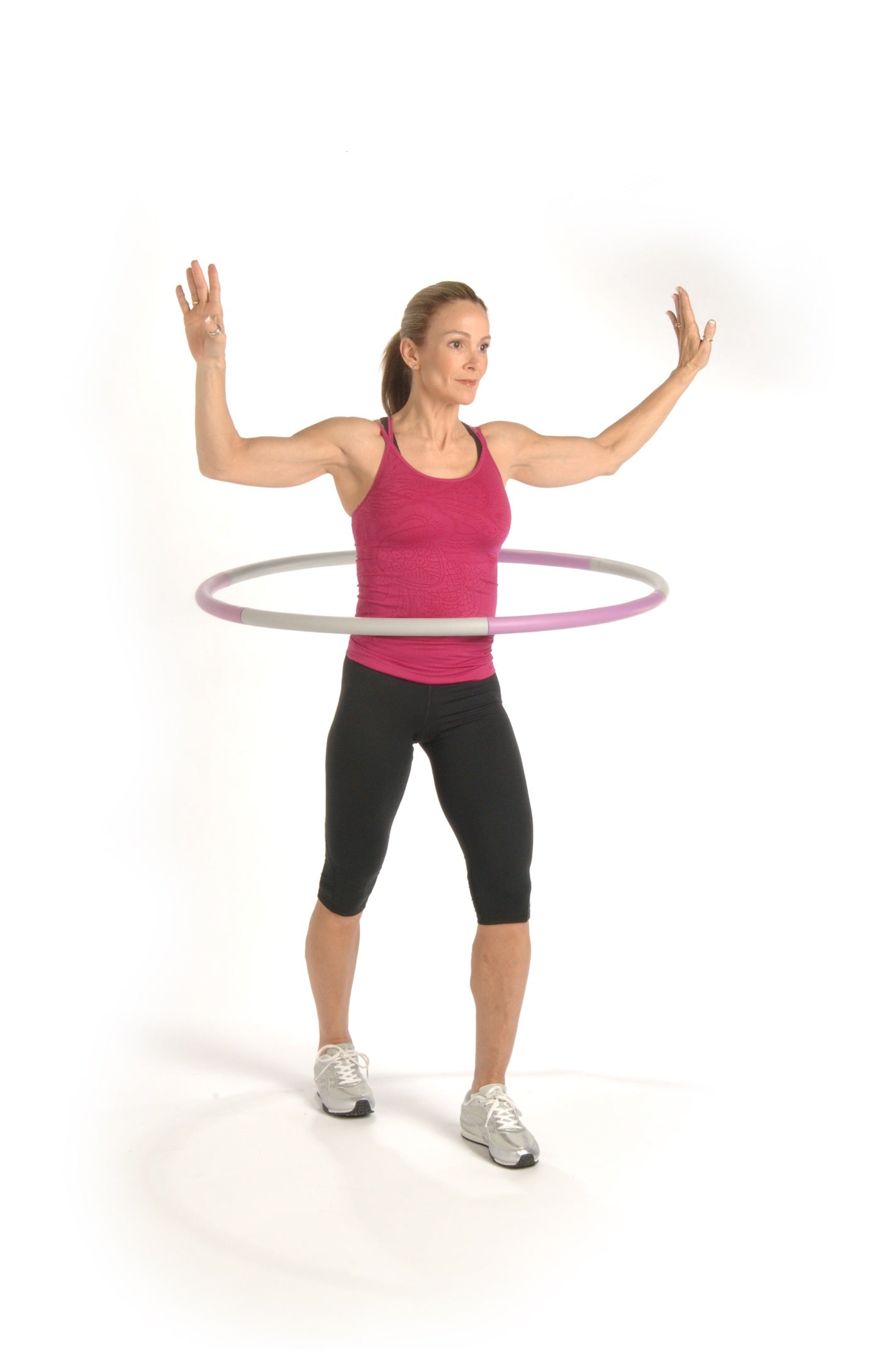 Woman exercising with a hula hoop on a white background