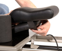 Person adjusting a black massage chair pad on a white background