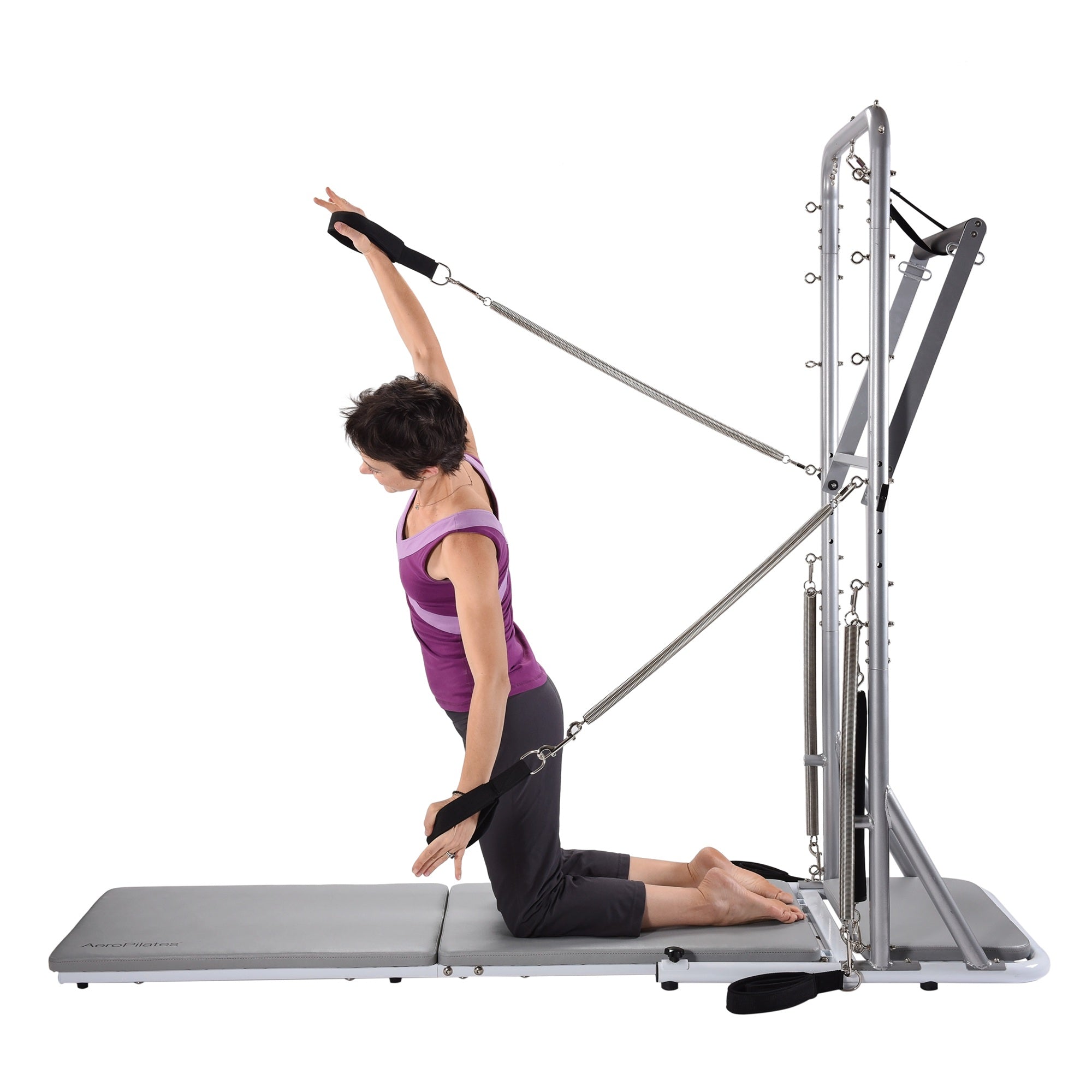 Woman using a Pilates reformer machine on a white background