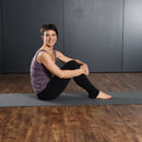 Woman sitting on a yoga mat in a studio setting