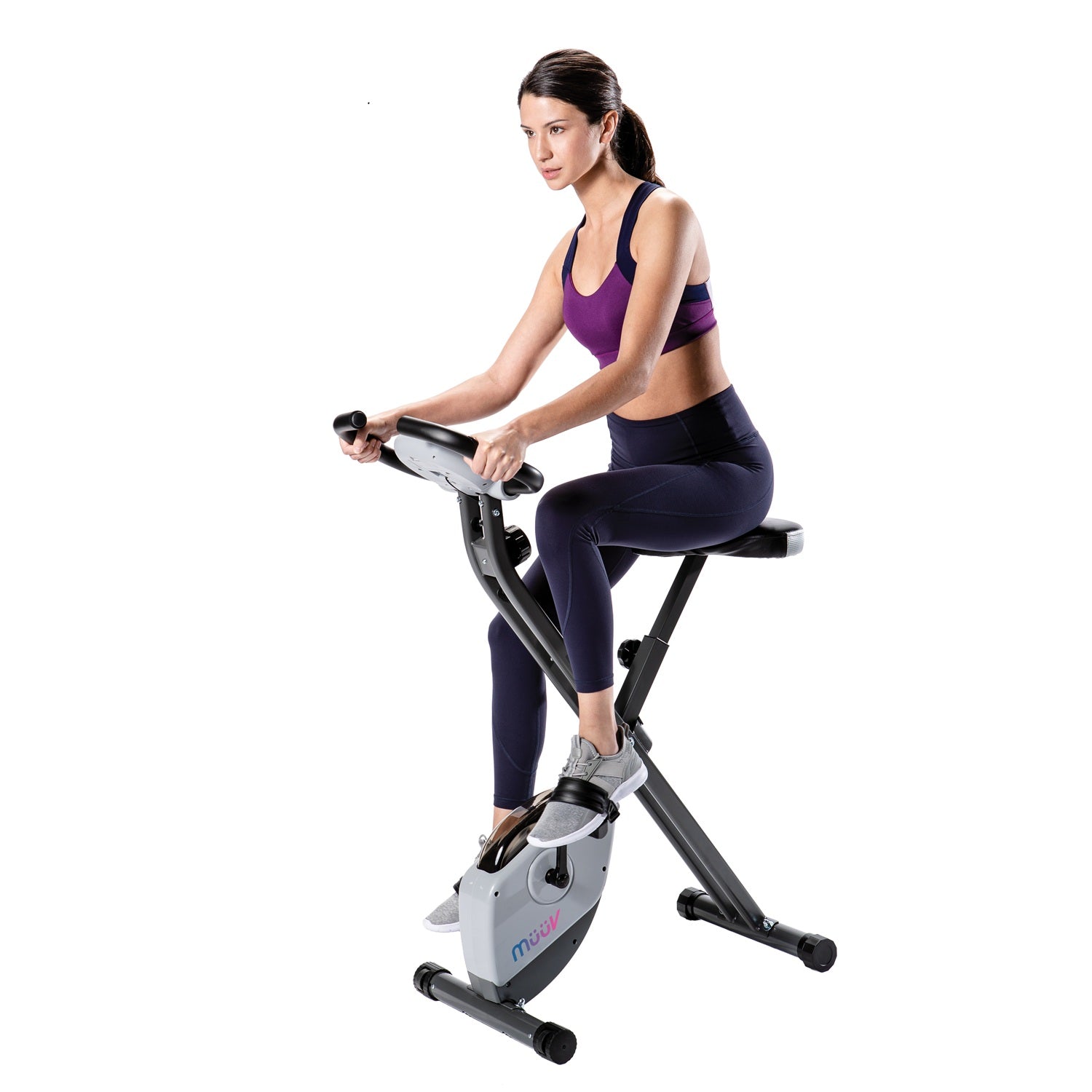 Woman exercising on a stationary bike against a white background