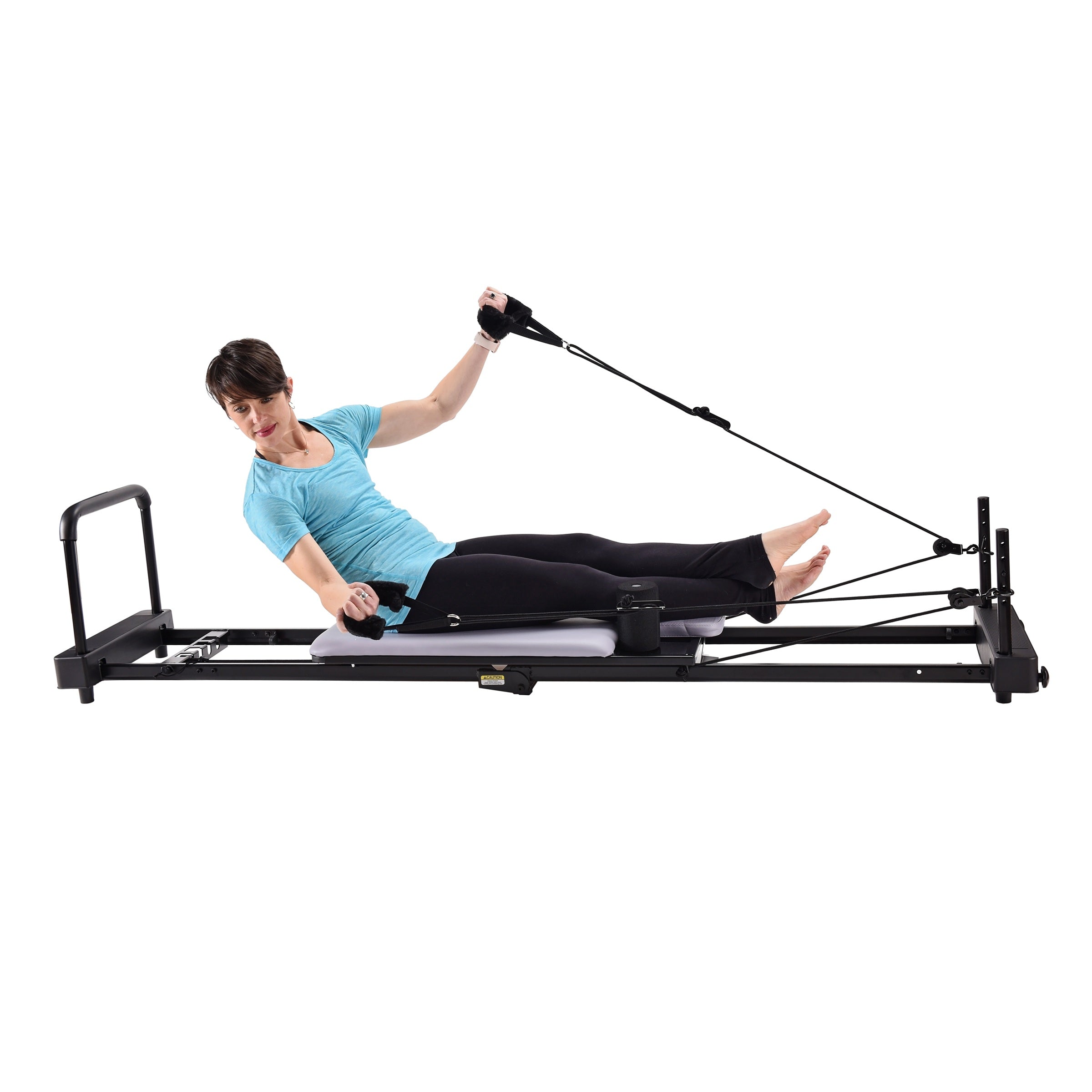 Person using a Pilates reformer machine on a white background