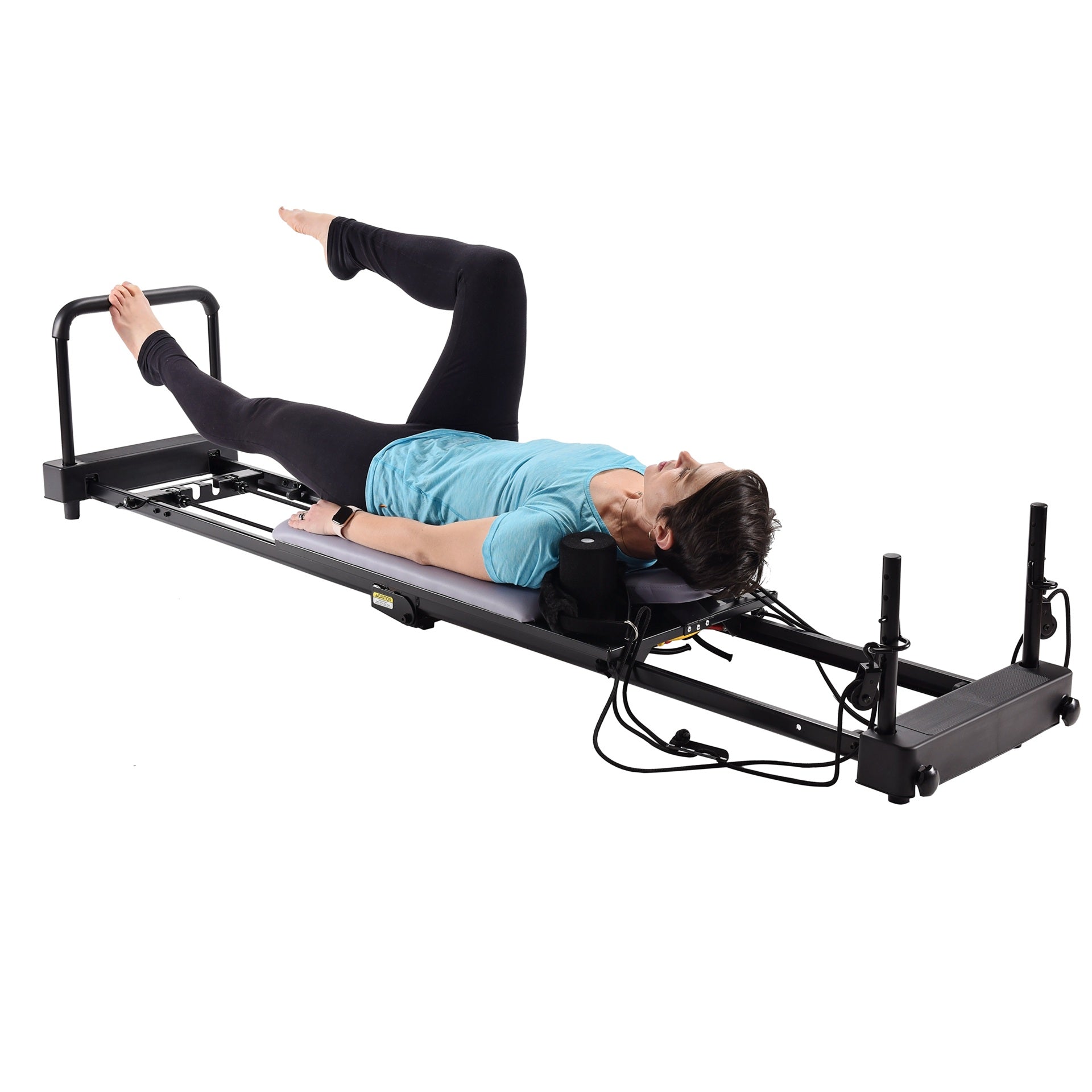 Person using a Pilates reformer machine on a white background