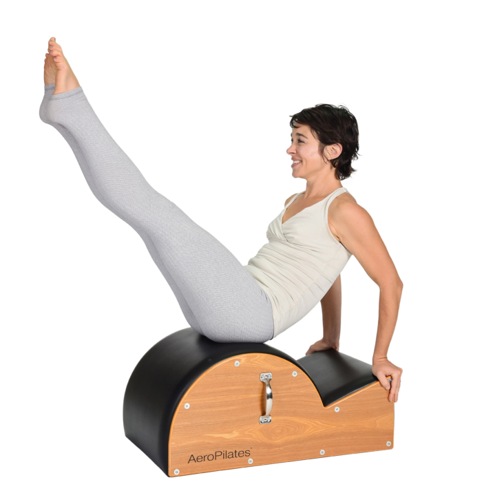 Woman bent legs upward while seated on Aeropilates Spine Corrector