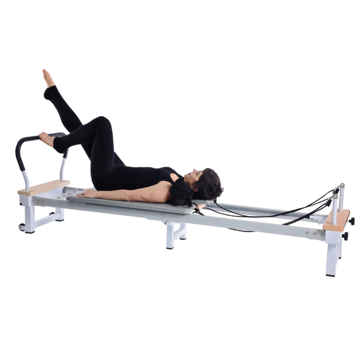 Woman lyind down on pilates while stepping the padded foot bar.