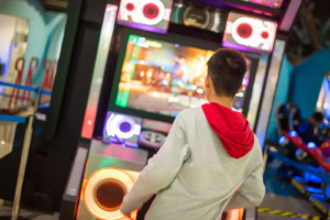 Young man playing gaming arcade