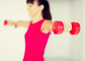 Woman holding hand weights close to camera