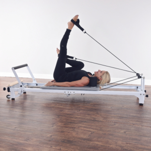 Woman lying down and leg straight up on Pilates.