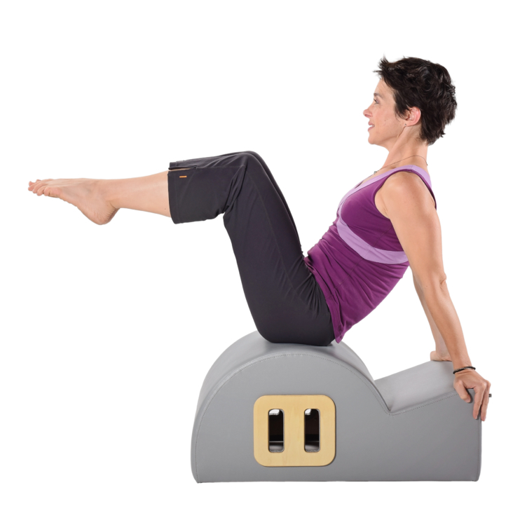 Sitting woman leaning back and lifting legs on spine corrector