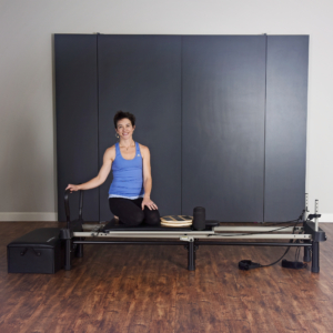 Woman seat on AeroPilates Reformer Workout with Box and Disk